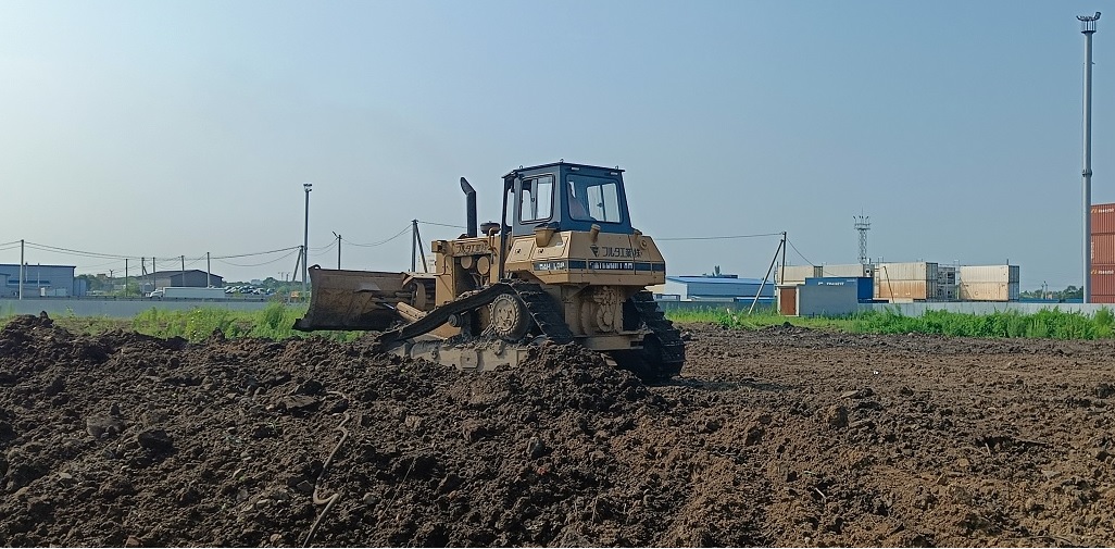 Бульдозер и экскватор роют и копают котлованы в Кингисеппе