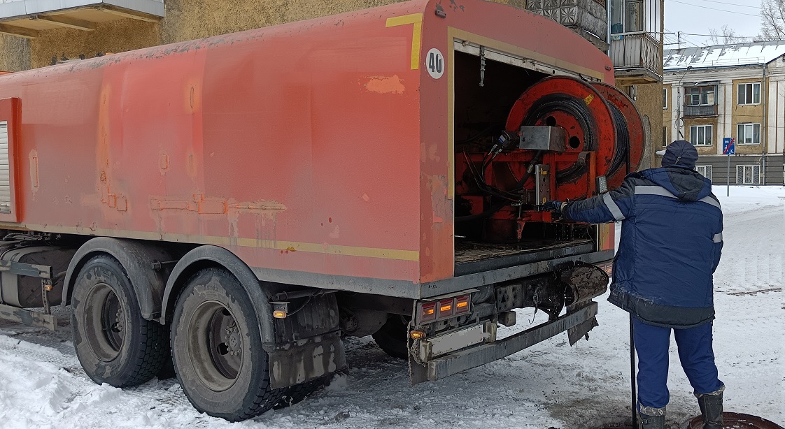 Каналопромывочная машина и работник прочищают засор в канализационной системе в Петергофе